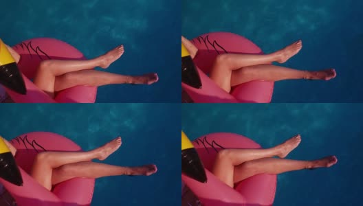 女人放松漂浮在粉红色火烈鸟充气在海上高清在线视频素材下载