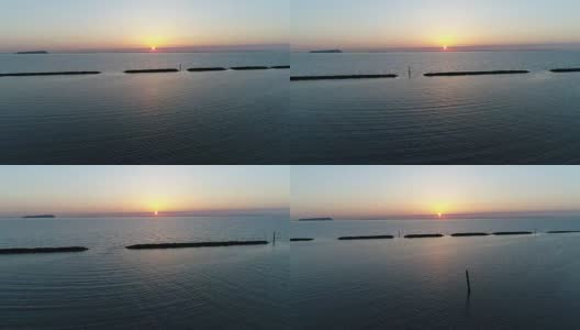 无人机飞，防波堤的石头在夕阳的海面上高清在线视频素材下载