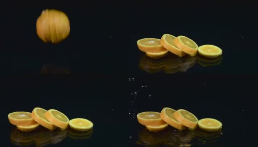橙子掉进水里就会分解成几片。黑色背景。慢动作高清在线视频素材下载