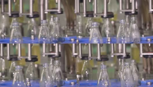 特写:药草饮料自动灌装机的玻璃透明瓶高清在线视频素材下载