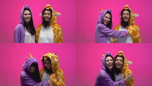 两个穿着独角兽和长颈鹿睡衣的女人笑着拥抱着，友谊高清在线视频素材下载