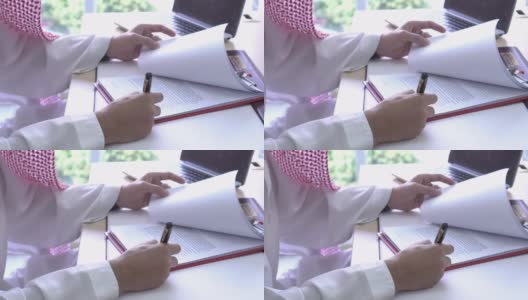 宽镜头阿拉伯人审查和签署文件高清在线视频素材下载