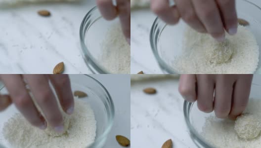 将白巧克力碗浸入/混合在玻璃碗里的干椰子中。准备自制椰子巧克力的概念。高清在线视频素材下载