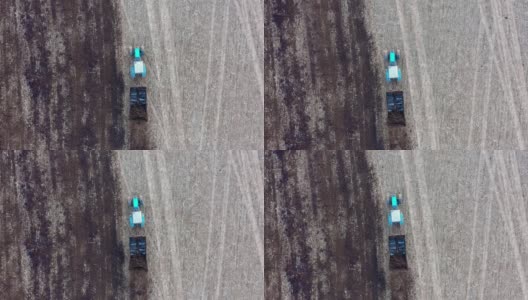 拖拉机拖着一拖车的粪肥穿过农村的农田，撒肥料高清在线视频素材下载