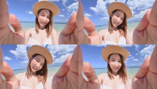 亚洲女人在比基尼拿着相机自画像在白色沙滩上高清在线视频素材下载