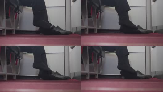 飞行时脚有臭味。男人的脚在飞机地板上擦着鞋子。高清在线视频素材下载