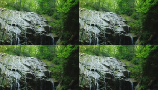 水流在巨大的岩石表面上，瀑布上方有美丽的绿色灯光。格伦伯尼瀑布附近吹岩石，北卡罗莱纳，美国。高清在线视频素材下载