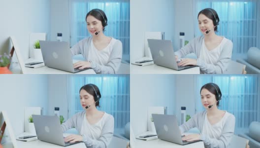 亚洲年轻的商业女性呼叫中心在晚上在家工作。漂亮的自由职业者女孩坐在桌子上戴着耳机，使用笔记本电脑和客户在晚些时候的工作会议在家里的客厅高清在线视频素材下载