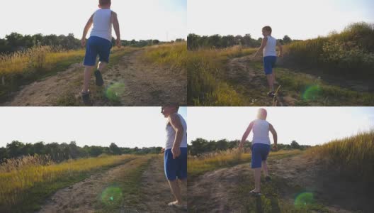 在阳光明媚的日子里，一个小男孩在田野附近的乡间小道上跑步。孩子在乡村小路上慢跑。快乐的微笑的男孩有乐趣在一个夏天的草地上的自然。慢镜头后景特写高清在线视频素材下载