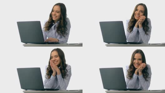 微笑的年轻女商人坐在办公桌旁，手提电脑高清在线视频素材下载