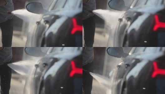 男人用高压水冲洗他的车。户外慢镜头高清在线视频素材下载
