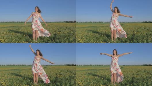 一个女人站在盛开的黄色田野里，穿着裙子，双手举向一边高清在线视频素材下载