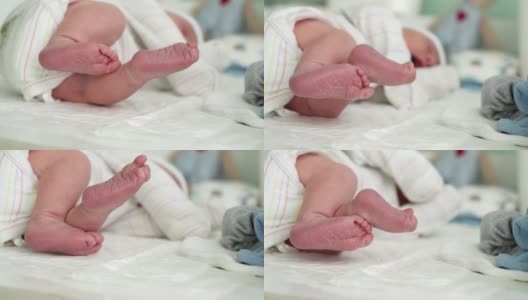可爱的小婴儿光脚和脚趾头的第一天的生活在白色的背景。婴儿小腿干燥皮肤的特写。妈妈在换尿布的桌上换尿布。童年,孕妇的概念。高清在线视频素材下载