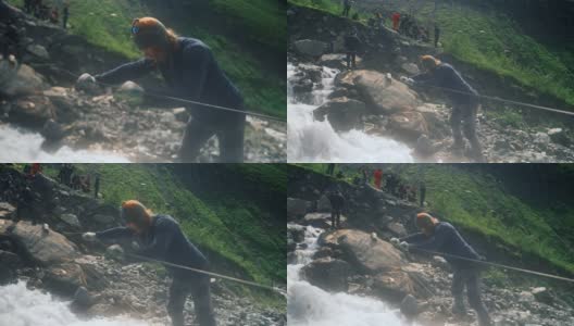 一位游客正在用绳索渡过一条湍急的山河高清在线视频素材下载