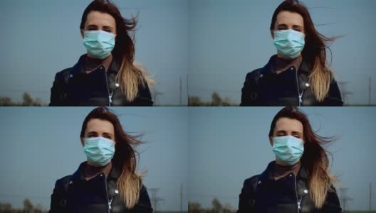 在蓝天下，戴着医用口罩的悲伤女性在镜头前呼吸新鲜空气，为抗击冠状病毒而奋战高清在线视频素材下载