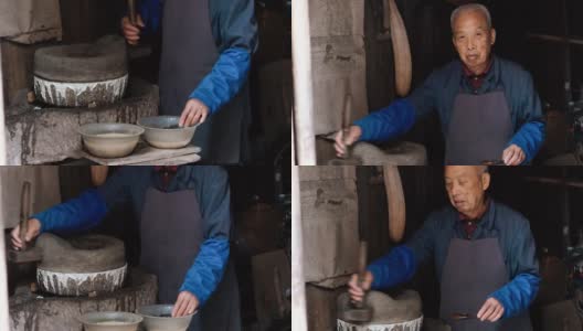 在中国古老的木质谷仓里碾磨谷物的高级工人高清在线视频素材下载