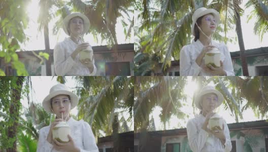 年轻女子在公园里喝椰子汁高清在线视频素材下载