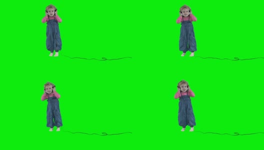 可爱的小女孩戴着大耳机在绿色背景上跳舞高清在线视频素材下载