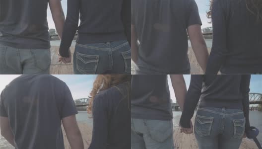日落时分，一对年轻的恋人在码头上散步时拥抱在一起高清在线视频素材下载