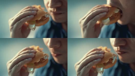 特写镜头里的人正在吃汉堡包。幸福的高清在线视频素材下载