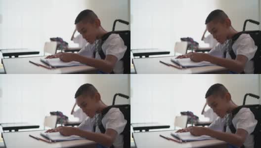 残疾学生在学校上课时做笔记高清在线视频素材下载