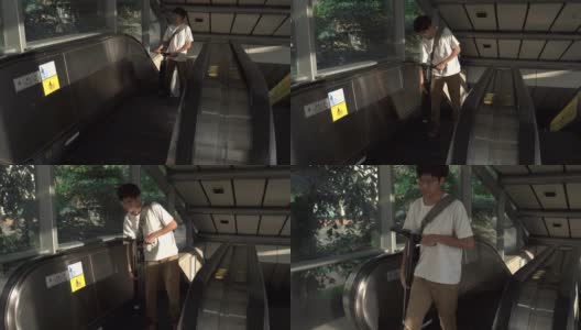 一名男子扛着电动车走出地铁站。高清在线视频素材下载
