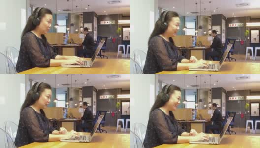 女亚裔员工在视频会议上微笑，拉丁裔男性在后面工作高清在线视频素材下载