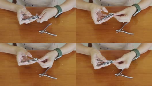 亚洲妇女在家里的木桌上用指甲钳剪指甲高清在线视频素材下载