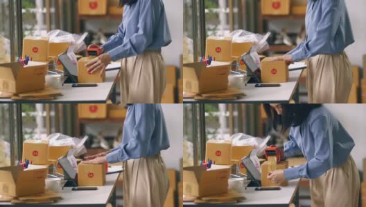 女工用胶带密封纸箱包装电子商务发货订单箱。高清在线视频素材下载