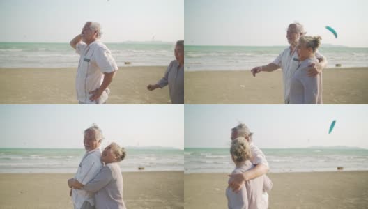 亚洲老夫妇手牵着手一起走在沙滩上，在夏天的日落。高清在线视频素材下载