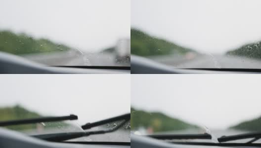 在能见度有限的情况下驾驶汽车:大雨，雨刷清洁挡风玻璃。高速公路上迎面而来的车辆开着前灯。恶劣天气条件下的道路安全。从车内看高清在线视频素材下载