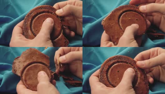 男人的手把糖饼干掰成一个圆圈的形状。高清在线视频素材下载
