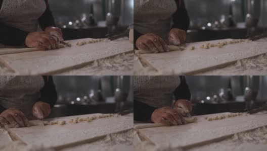 在意大利面厂内，一名妇女正在为新鲜的土豆团准备和切面团高清在线视频素材下载