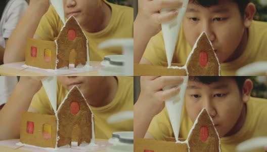 亚洲男孩和妹妹在晚上在家做姜饼屋，庆祝圣诞节的生活理念。高清在线视频素材下载