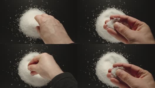上图:一名男子的手从一堆海盐中取出一小撮海盐高清在线视频素材下载