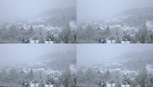 雪落在树木繁茂的山脚下的小村庄高清在线视频素材下载