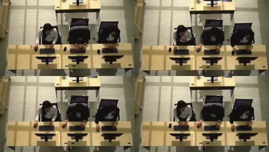 俯视图微笑的接线员男人和女人与耳机工作在一个呼叫中心高清在线视频素材下载