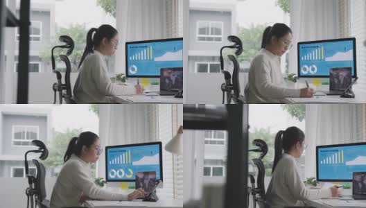 宽镜头的年轻迷人的亚洲女人忙着工作的多屏幕电脑和智能平板电脑在桌子上在家里的概念自由职业者数据分析师，数据科学家的业务。高清在线视频素材下载
