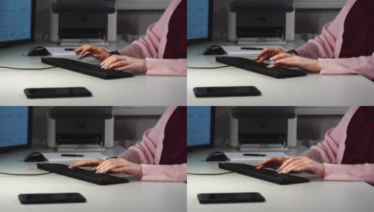 一个年轻女子的手在办公室敲击电脑键盘的特写高清在线视频素材下载