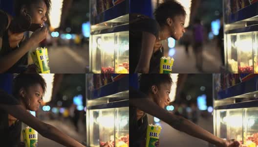 年轻女子晚上在街上品尝当地美食高清在线视频素材下载