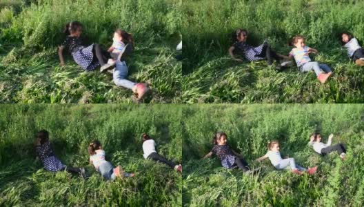 小女孩们在田野的草地上打滚高清在线视频素材下载