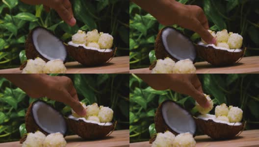 近距离拍摄的手采摘甜椰子球从椰子壳。传统印度甜品也被称为Kopra pak。高清在线视频素材下载