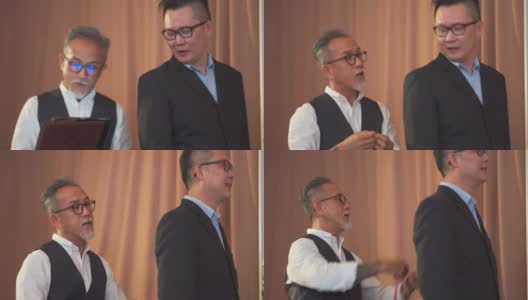 亚洲华人高级男裁缝用卷尺测量他的客户的身体尺寸为新的运动夹克在工作室制作，并写下数字平板电脑记录数字高清在线视频素材下载