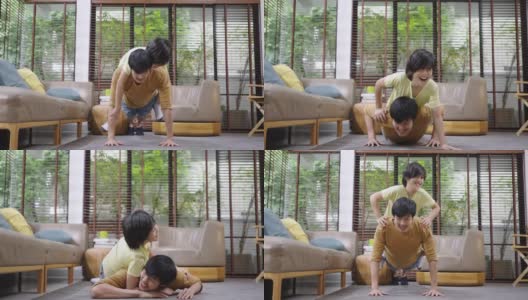 亚洲父亲和儿子在家里一起做俯卧撑。高清在线视频素材下载