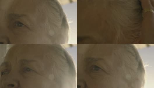 白发苍苍的老妇人在夕阳中轻抚着她的发带高清在线视频素材下载