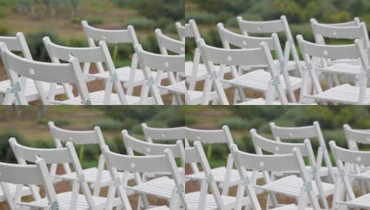 在婚礼现场，各种各样的白色折叠椅被雨水打湿高清在线视频素材下载