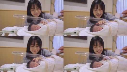 一位年轻的母亲在医院抚摸着她刚出生的婴儿高清在线视频素材下载