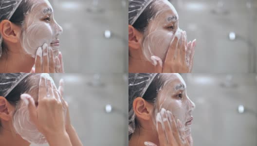 年轻的亚洲妇女在家里的浴室里洗脸高清在线视频素材下载