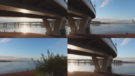 从芬兰湾远眺，高速公路运输系统的多层次立交公路弯道桥上的晨曦日出美景尽收眼底。俄罗斯圣彼得堡，渔民在海滩上捕鱼高清在线视频素材下载
