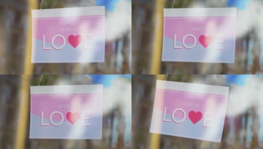 入口玻璃门上刻有“HERE IS LOVE”字样的标牌，4k慢镜头60fps高清在线视频素材下载